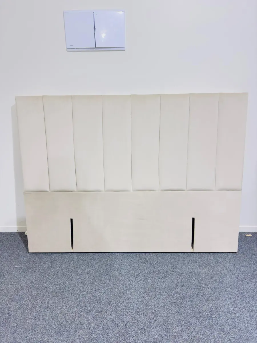 A cream fluted headboard with narrow vertical channels.