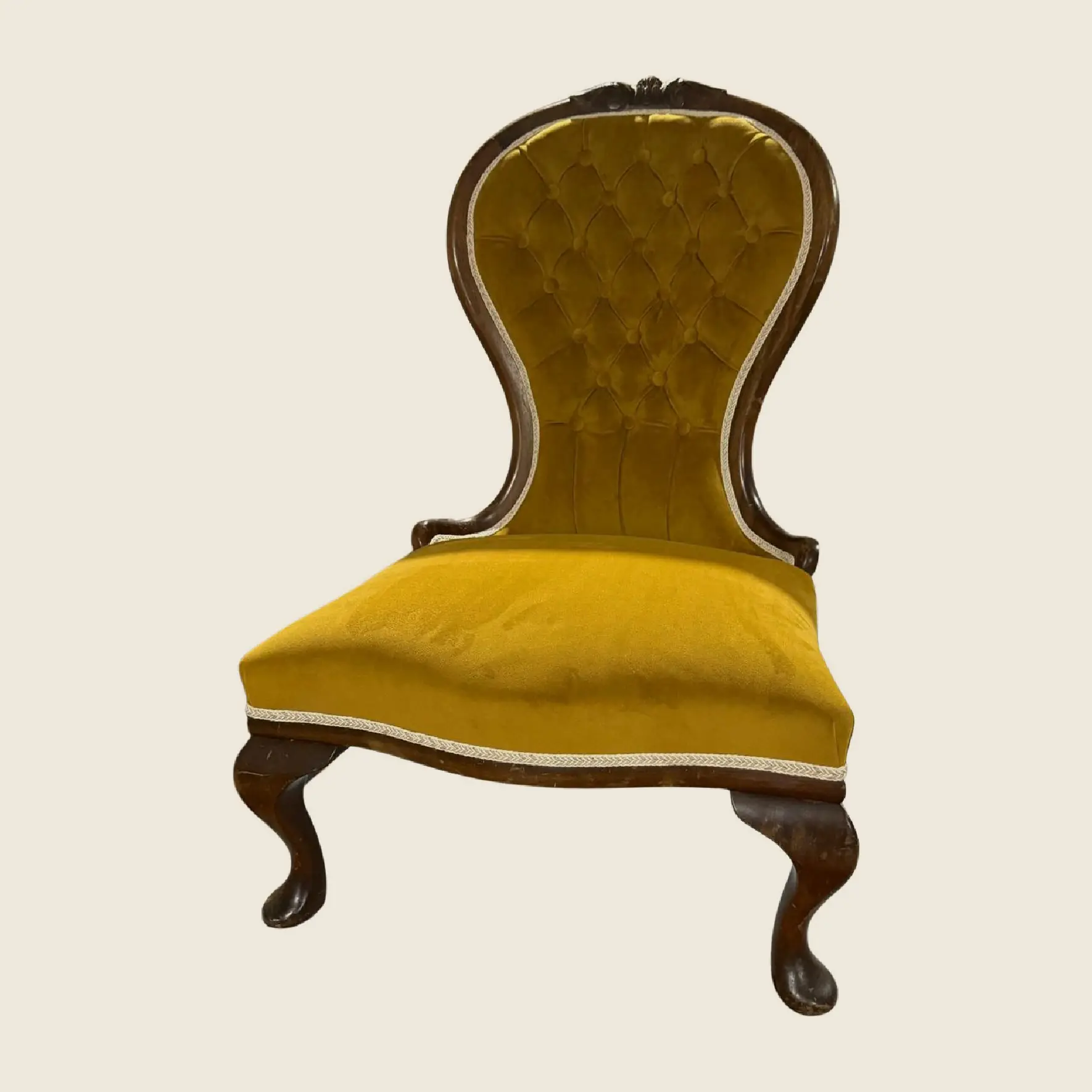 A yellow velvet button-tufted chair, front three-quarter view